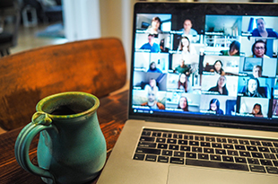 A zoom meeting is displayed on a laptop.