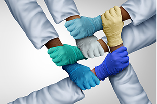 Healthcare workers link arms.
