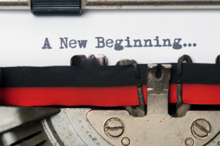 The text, "A New Beginning..." is typed on a sheet of paper that is in a type writer.