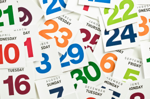 Calendar squares with brightly-colored numbers are piled on top of eachother at random.