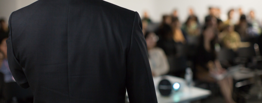 A man presents to conference attendees.