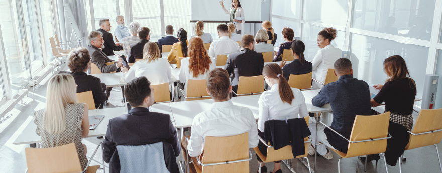 A woman presents to a room of conference attendees.