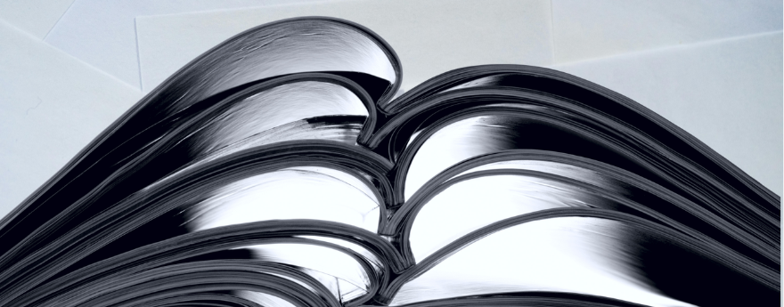 A stack of journals lie open on a table.