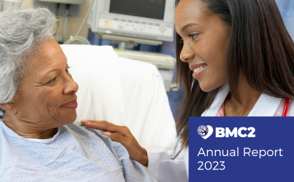 The words "2023 Annual Report" and the BMC2 logo are in white on a bright blue background next to an image of a younger Black health care professional talking with an older Black patient.